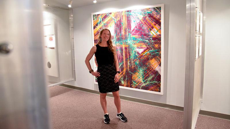 Heidi Manfred stands in front of her piece, Joyful, at the opening of her Emotions in Art exhibit.